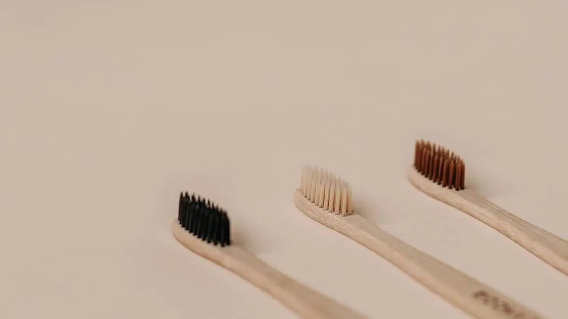 Eco-friendly wooden toothbrushes showcasing diverse bristle colors, illustrating tooth brushing techniques.