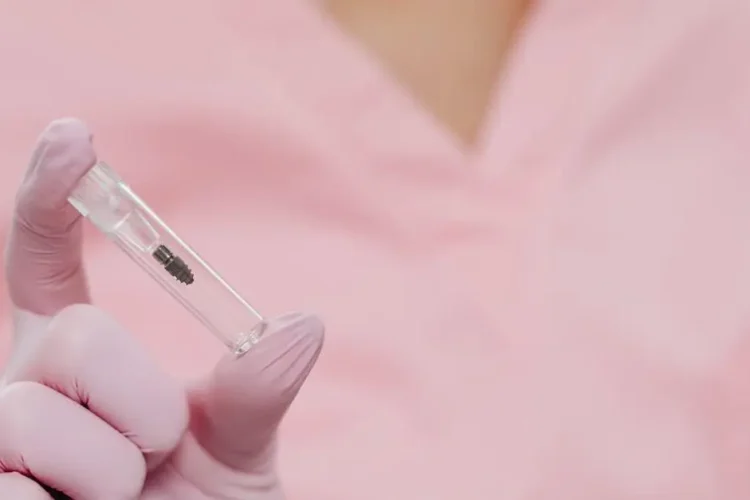 Dental implant held by a nurse in a sterile setting, showcasing what to expect from dental implant surgery.