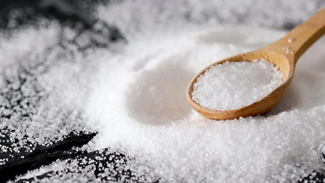 Wooden spoon with fine sea salt highlights xylitol tooth decay prevention benefits.